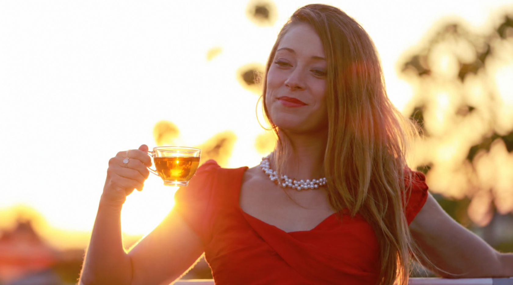 Founder of Aura Medicinals raising a cup of tea at sunset